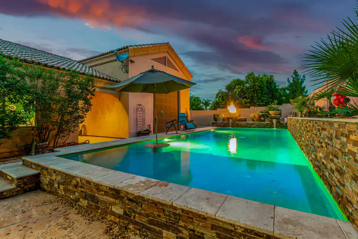 Resort-style luxury vacation rental pool home in the Arizona desert at dusk